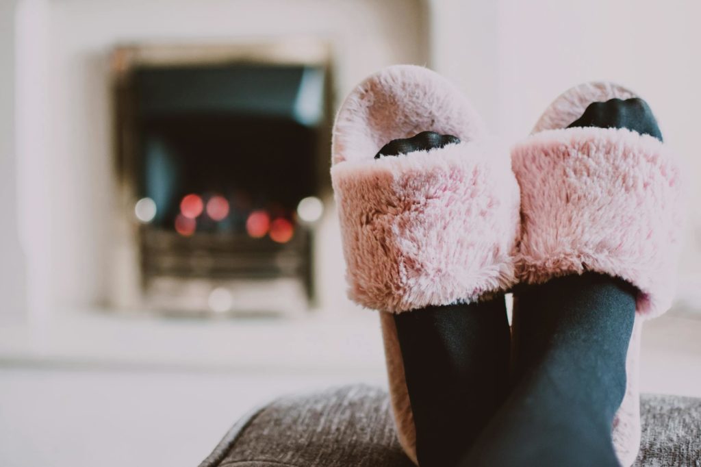 close up photography of person wearing pink house slippers